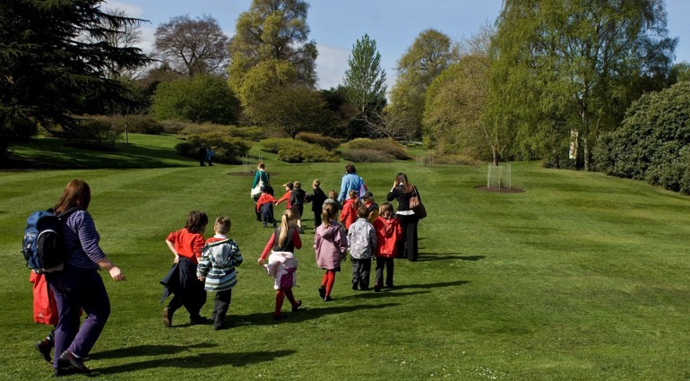 A school class waling across a lawn in the Garden