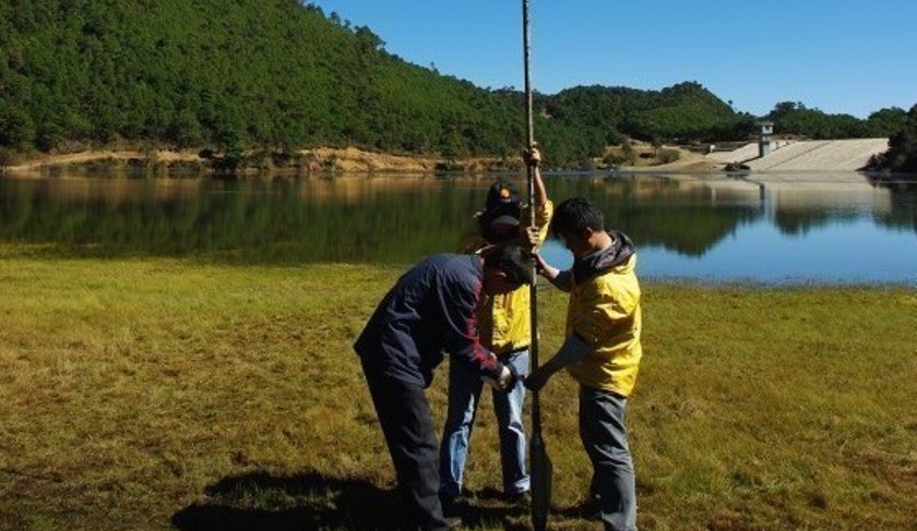 Three researchers carry out sediment coring at Haligu, China